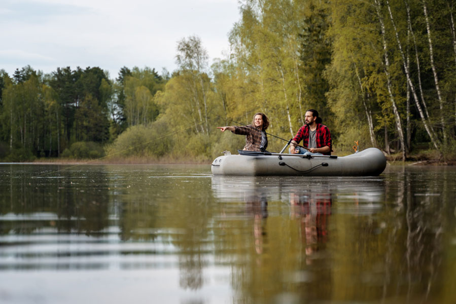 Anglerin und Angler sitzen in einem Schlauchboot auf einem See