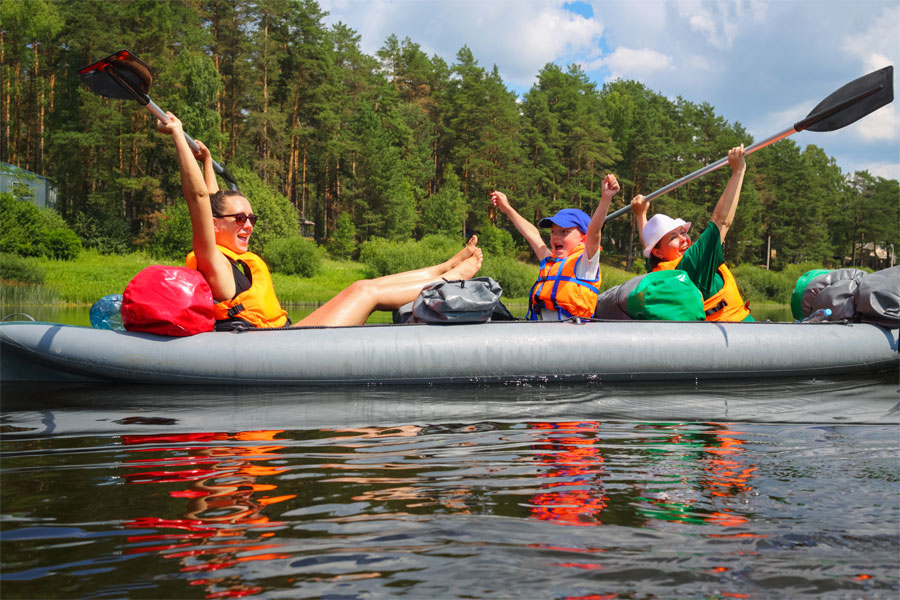 Fröhliche Familie auf dem Wasser streckt die Arme in die Höhe