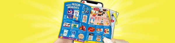 Diese Grafik zeigt auf gelbem Strahlenhintergrund zwei H&auml;nde, die vor einem Smartphone ein aufgeklapptes digitales Wochenprospekt halten; auf der linken Seite steht die &Uuml;berschrift &bdquo;Unsere Frische-Highlights&ldquo;, im Prospekt sind mehrere Angebote aus dem Frischebereich mit Produktabbildungen zu sehen, darunter unter anderem Rama, M&ouml;venpick, Skyr, S&uuml;&szlig;waren sowie weitere K&uuml;hl- und Aktionsartikel, auf der rechten oberen Prospektseite steht &bdquo;Italienische Spezialit&auml;ten&ldquo; und unten l&auml;dt ein Button mit der Aufschrift &bdquo;Zum digitalen Wochenprospekt&ldquo; zum Klicken ein.
