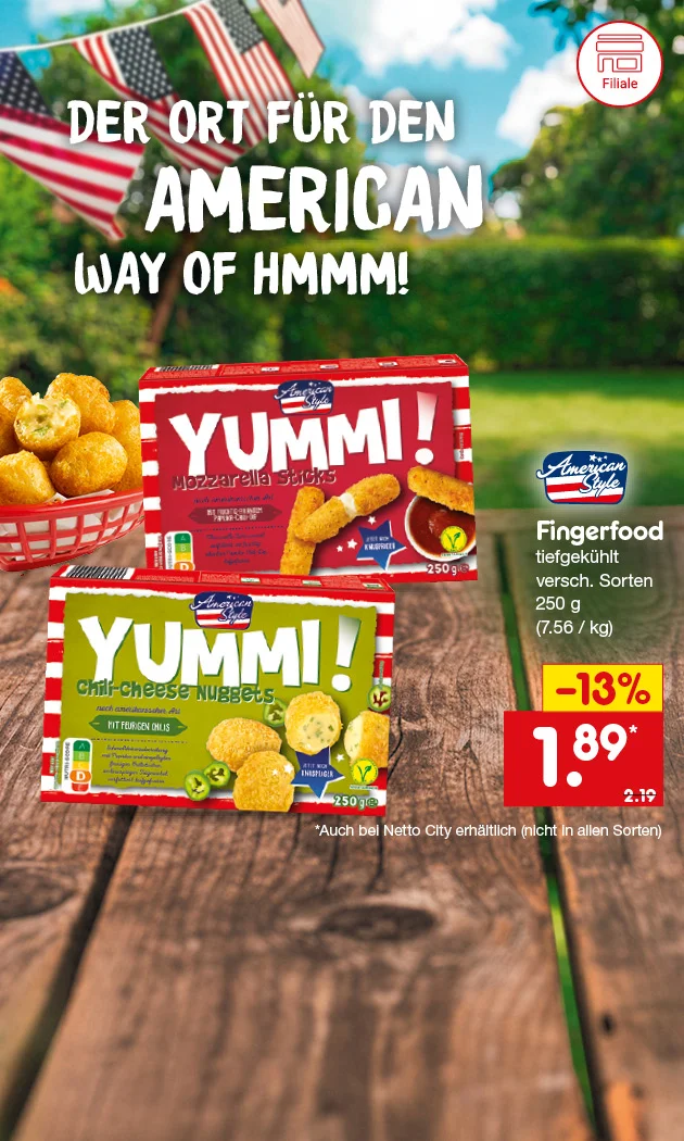 Diese Grafik zeigt den Slogan &bdquo;Der Ort f&uuml;r den American Way of Hmmm!&ldquo;, zwei Packungen American Style Fingerfood tiefgek&uuml;hlt in verschiedenen Sorten, darunter Mozzarella Sticks und Nuggets, jeweils mit zweihundertf&uuml;nfzig Gramm, dazu passende Produktabbildungen und eine Schale mit Snacks auf einem Holztisch vor unscharfem Hintergrund mit USA-Flaggen. Rechts stehen die Produktangaben &bdquo;Fingerfood, tiefgek&uuml;hlt, verschiedene Sorten, zweihundertf&uuml;nfzig Gramm&ldquo; sowie die Grammatur in Klammern &bdquo;sieben Euro sechsundf&uuml;nfzig pro Kilogramm&ldquo;, der Preis von einem Euro neunundachtzig statt zwei Euro neunzehn und der Hinweis &bdquo;minus dreizehn Prozent&ldquo;. Unten links ist ein Filiale-Symbol zu sehen. Unten rechts befindet sich ein Button mit der Aufschrift &bdquo;Jetzt Angebote entdecken&ldquo;, der zum Klicken einl&auml;dt.