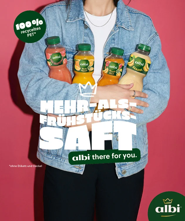 Auf dem Bild sieht man vor rosafarbenem Hintergrund den Oberk&ouml;rper einer Person in Jeansjacke, die vier albi-Saftflaschen im Arm h&auml;lt. Links steht gro&szlig; &bdquo;Mehr-als-Fr&uuml;hst&uuml;cks-Saft&ldquo;, darunter &bdquo;albi there for you.&ldquo; Oben links ein gr&uuml;ner Kreis mit &bdquo;hundert Prozent recyceltes PET*&ldquo;. Unten links der Sternchentext &bdquo;*ohne Etikett und Deckel&ldquo;. Unten rechts ist das albi-Logo zu sehen. Die Flaschen zeigen verschiedene Sorten in rosa, gelb, orange und hellgelb. Preis- und Grammaturangaben sind auf der Grafik nicht sichtbar.