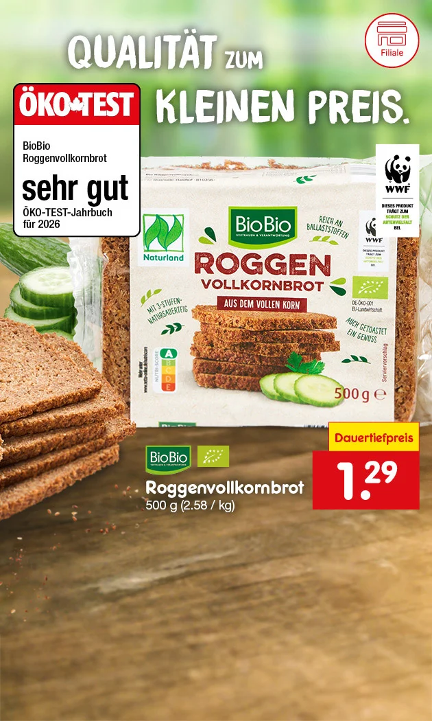 Die Grafik zeigt eine Packung BioBio Roggenvollkornbrot mit mehreren Brotscheiben davor, dekoriert mit Gurkenscheiben. Im Hintergrund ist ein grüner, unscharfer Natur-Look. Links steht groß „Qualität zum kleinen Preis“. Daneben ein ÖKO-TEST-Siegel mit dem Text: „BioBio Roggenvollkornbrot sehr gut, ÖKO-TEST-Jahrbuch für zweitausendsechsundzwanzig“. Rechts oben das WWF-Logo mit dem Hinweis „Unterstützt den WWF Deutschland“. Rechts neben der Brotpäckchen steht: „BioBio Roggenvollkornbrot, BioBio, fünfhundert Gramm, zwei Euro achtundfünfzig pro Kilogramm“. Unten rechts ein gelbes Feld mit „Dauer Tiefpreis“ und ein rotes Feld mit dem Preis „einen Euro neunundzwanzig“. In der Mitte ein weißes Feld mit rotem Rand und dem Text „Hier mehr erfahren“, der zum Klicken einlädt.