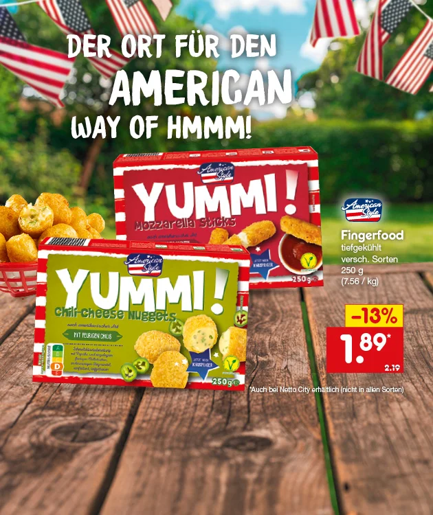 Diese Grafik zeigt den Slogan &bdquo;Der Ort f&uuml;r den American Way of Hmmm!&ldquo;, zwei Packungen American Style Fingerfood tiefgek&uuml;hlt in verschiedenen Sorten, darunter Mozzarella Sticks und Nuggets, jeweils mit zweihundertf&uuml;nfzig Gramm, dazu passende Produktabbildungen und eine Schale mit Snacks auf einem Holztisch vor unscharfem Hintergrund mit USA-Flaggen. Rechts stehen die Produktangaben &bdquo;Fingerfood, tiefgek&uuml;hlt, verschiedene Sorten, zweihundertf&uuml;nfzig Gramm&ldquo; sowie die Grammatur in Klammern &bdquo;sieben Euro sechsundf&uuml;nfzig pro Kilogramm&ldquo;, der Preis von einem Euro neunundachtzig statt zwei Euro neunzehn und der Hinweis &bdquo;minus dreizehn Prozent&ldquo;. Unten links ist ein Filiale-Symbol zu sehen. Unten rechts befindet sich ein Button mit der Aufschrift &bdquo;Jetzt Angebote entdecken&ldquo;, der zum Klicken einl&auml;dt.