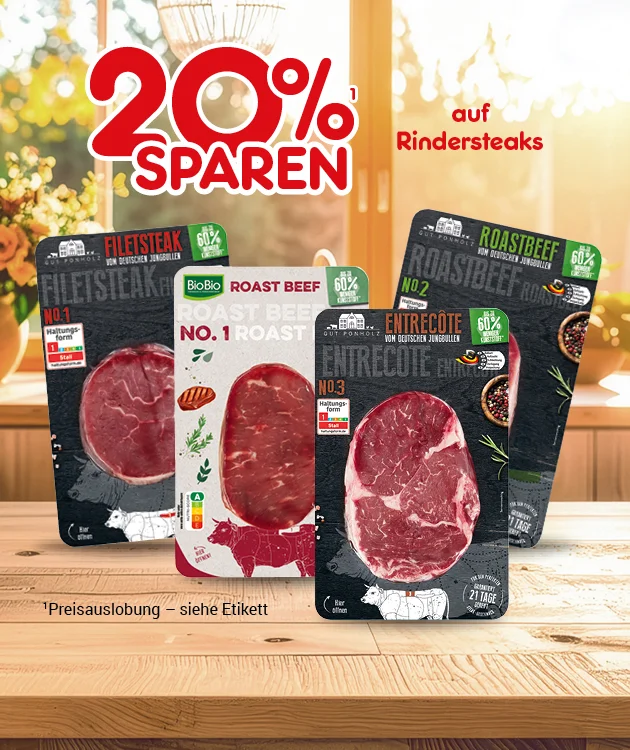 Diese Grafik zeigt abgepackte Rindersteaks auf einer Holzarbeitsplatte vor einer hellen, leicht unscharfen K&uuml;chen-/Theken-Szene mit der Aufschrift &bdquo;zwanzig Prozent sparen auf Rindersteaks&ldquo; sowie dem Button &bdquo;Weitere Sparangebote entdecken&ldquo;, der unten zum Klicken einl&auml;dt.