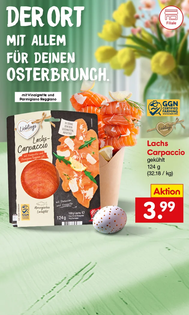 Fr&uuml;hlingshaftes Motiv mit hellgr&uuml;nem Tisch und unscharfem Fenster im Hintergrund: links gelbe Tulpen in einer Glasvase, unten links ein wei&szlig;es Osterei mit orangefarbenen Punkten; mittig vorne steht eine kleine Papier-T&uuml;te, gef&uuml;llt mit aufgerollten Lachsscheiben und Zitronenspalten. Gro&szlig;e wei&szlig;e &Uuml;berschrift links: &bdquo;DER ORT MIT ALLEM F&Uuml;R DEINEN OSTERBRUNCH.&ldquo; Darunter in einem wei&szlig;en Kasten der Hinweis: &bdquo;mit Vinaigrette und Parmigiano Reggiano&ldquo;. Rechts ist eine Packung &bdquo;Lieblings Lachs-Carpaccio&ldquo; abgebildet; auf der Packung stehen unter anderem &bdquo;Lachs-Carpaccio&ldquo;, ein rotes Band mit &bdquo;mit Vinaigrette und Parmigiano Reggiano&ldquo;, sowie &bdquo;einhundertvierundzwanzig Gramm&ldquo;. Oben rechts im Bild ein blau-gelbes Siegel &bdquo;GGN CERTIFIED FARMING&ldquo; mit &bdquo;WWW.GGN.ORG&ldquo;; daneben ein herzf&ouml;rmiges &bdquo;Lieblings&ldquo;-Anh&auml;nger-Label. Rechts neben der Packung stehen die Produktangaben: &bdquo;Lachs Carpaccio&ldquo;, &bdquo;gek&uuml;hlt&ldquo;, &bdquo;einhundertvierundzwanzig Gramm&ldquo; und &bdquo;dreiunddrei&szlig;ig Euro achtzehn pro Kilogramm&ldquo;. Unten rechts ein rotes Preisschild mit gelbem Feld &bdquo;Aktion&ldquo; und gro&szlig;em Preis &bdquo;drei Euro neunundneunzig&ldquo;. Ganz unten rechts ein wei&szlig; umrandeter Button mit roter Schrift &bdquo;Jetzt Angebote entdecken&ldquo;, der zum Klicken einl&auml;dt. Links unten ein kleines rundes Symbol mit der Aufschrift &bdquo;Filiale&ldquo;.