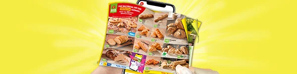 Diese Grafik zeigt auf gelbem Hintergrund zwei H&auml;nde, die ein Smartphone mit dem digitalen Wochenprospekt halten. Auf dem Display sind viele Backwaren wie Brote, Br&ouml;tchen, Croissants, Brezeln und herzhafte Snacks zu sehen. Oben links stehen das Netto-Logo und ein roter Hinweis mit der Aufschrift &bdquo;Das Backregal mit der gr&ouml;&szlig;ten Auswahl&ldquo;. Unten l&auml;dt ein gro&szlig;er Button mit der Aufschrift &bdquo;Zum digitalen Wochenprospekt&ldquo; zum Klicken ein.
