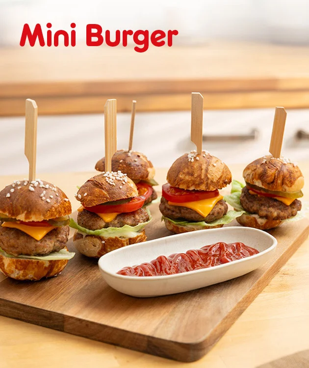 Zu sehen ist eine Rezeptgrafik mit vier Mini-Burgern auf einem Holzbrett. Die Burger sind mit kleinen Holzspie&szlig;en fixiert und mit K&auml;se, Tomate, Salat und Fleisch belegt. Rechts unten steht eine wei&szlig;e Schale mit Ketchup. Oben links liest man Mini Burger. Unten befindet sich ein wei&szlig;er Button mit roter Umrandung und dem Text Hier Rezept entdecken.
